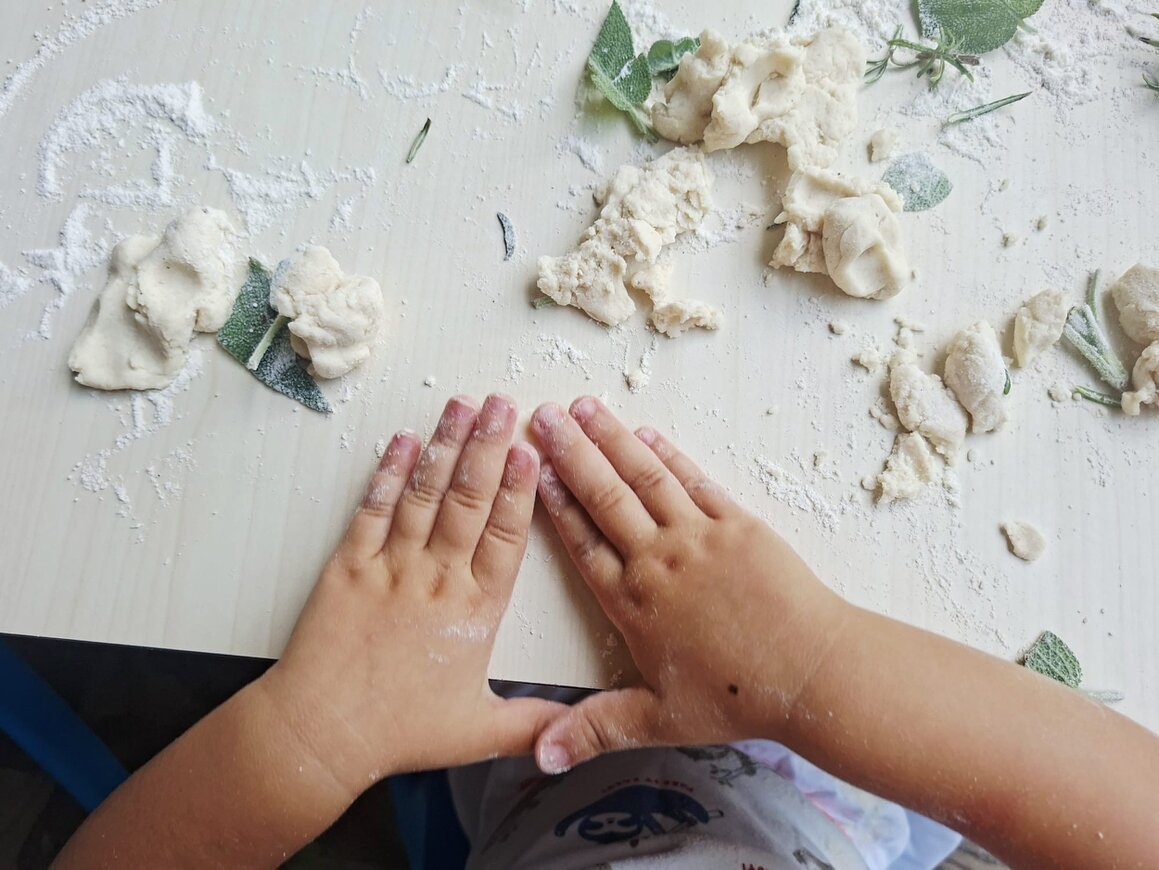 Bambini che incollano carte colorate su un cartellone