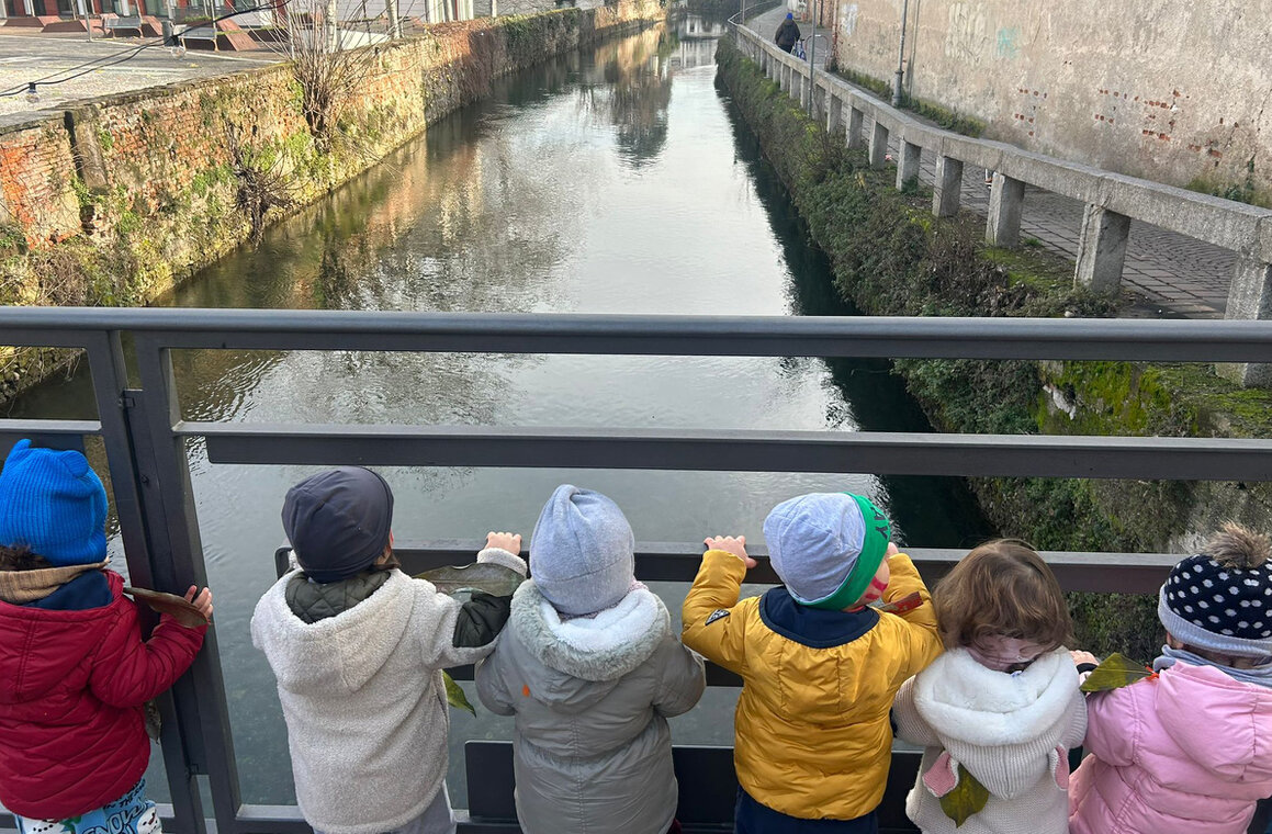 Bambini che giocano in giardino con scivolo e prato