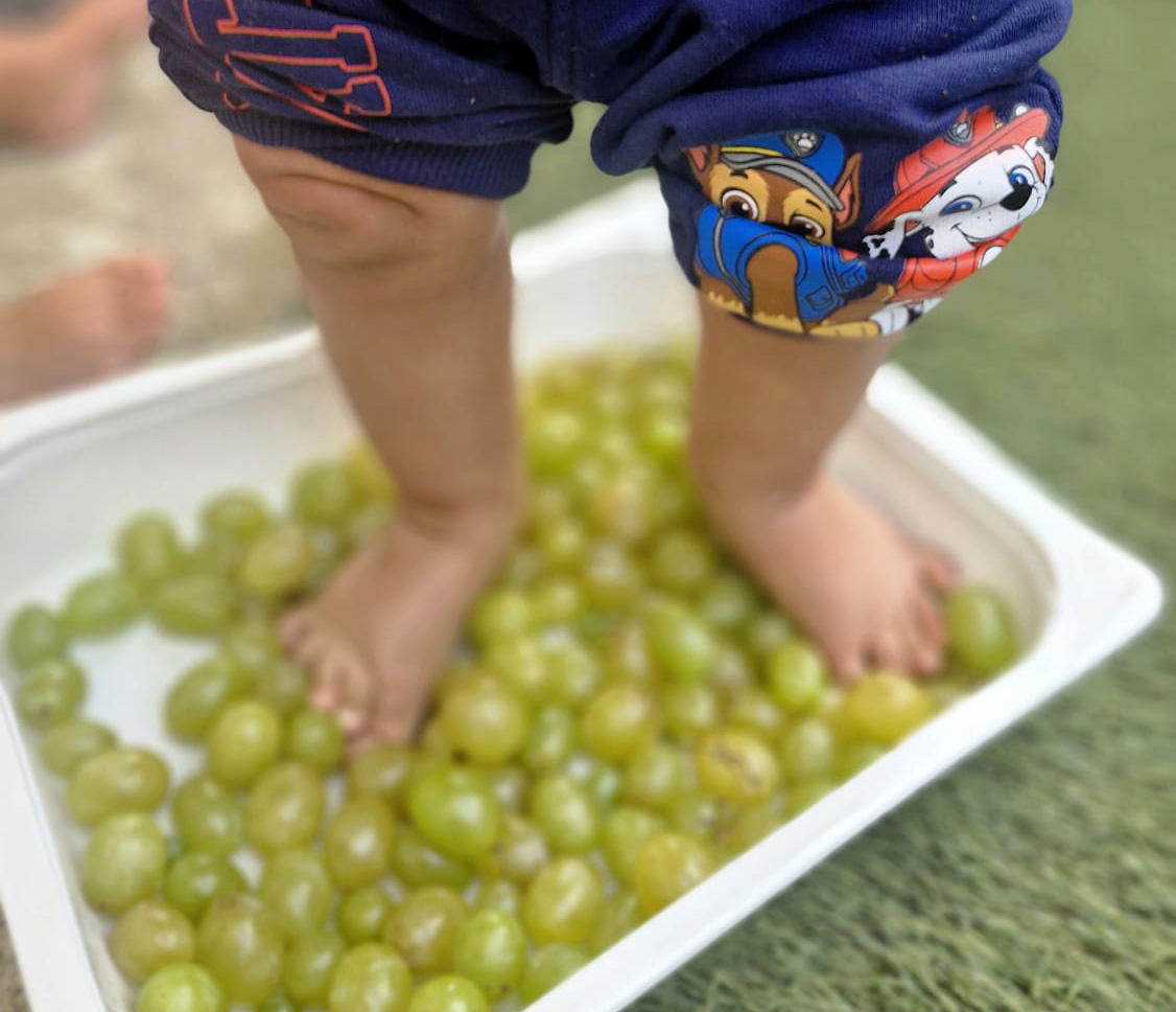 Bambino che dipinge con le mani su un grande foglio