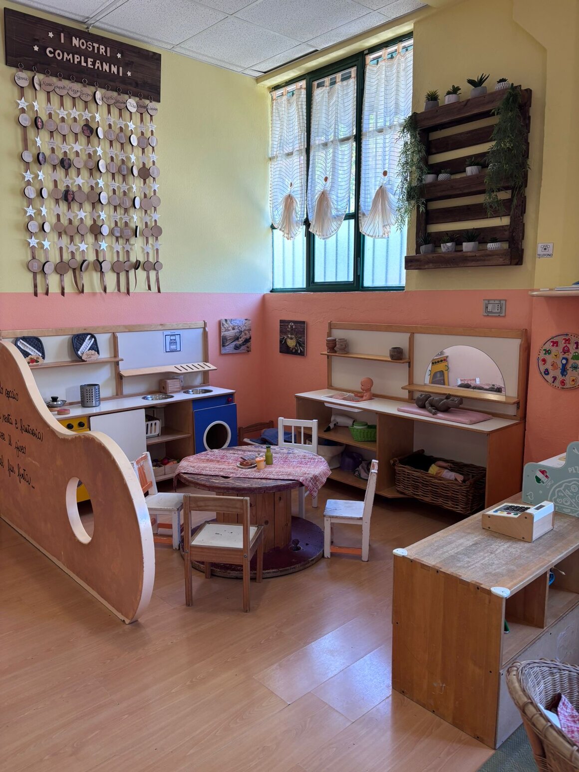 Sala giochi colorata con tavolini, sedie e scaffali a misura di bambino
